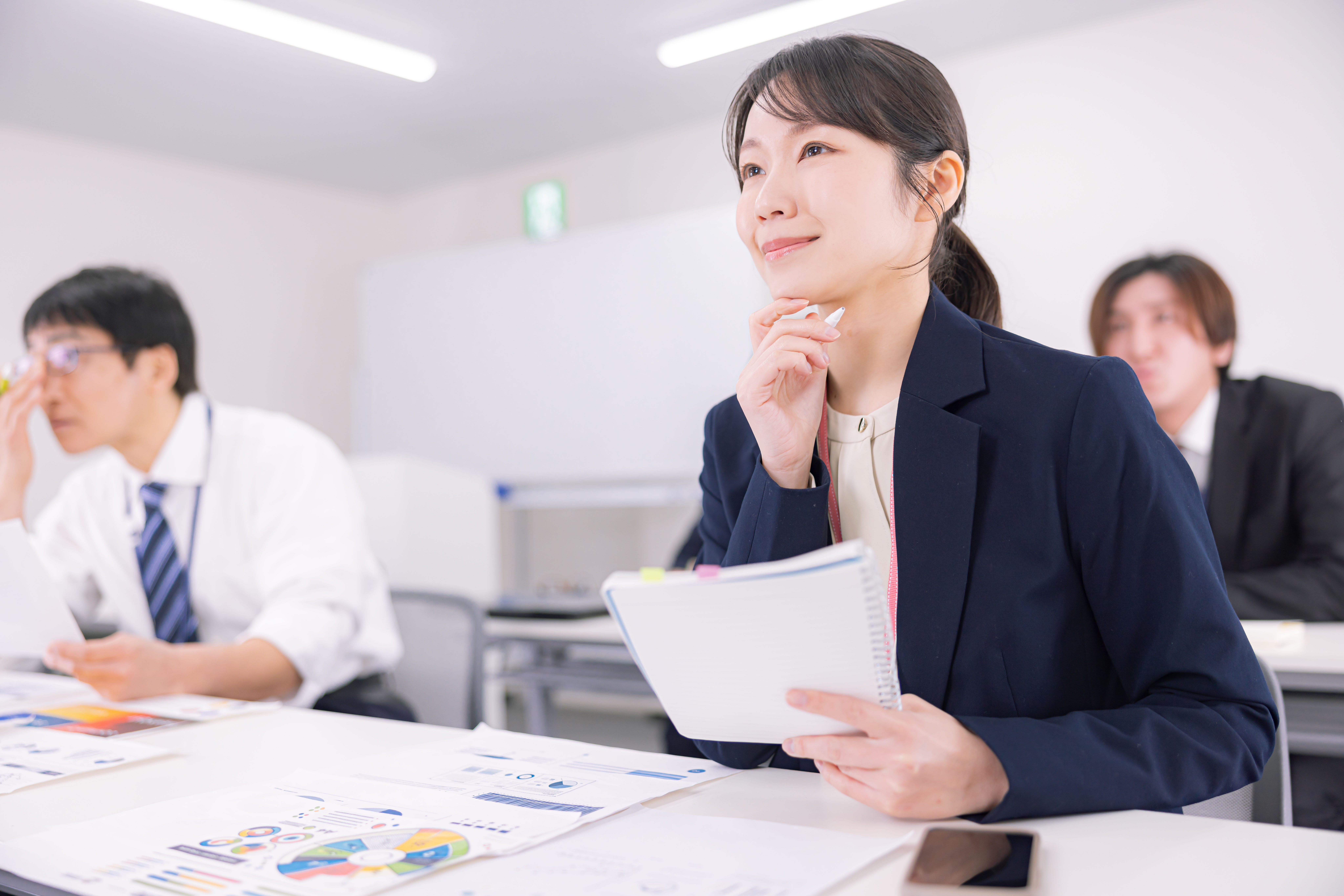 資料を眺めながらセミナーに参加する社員たち